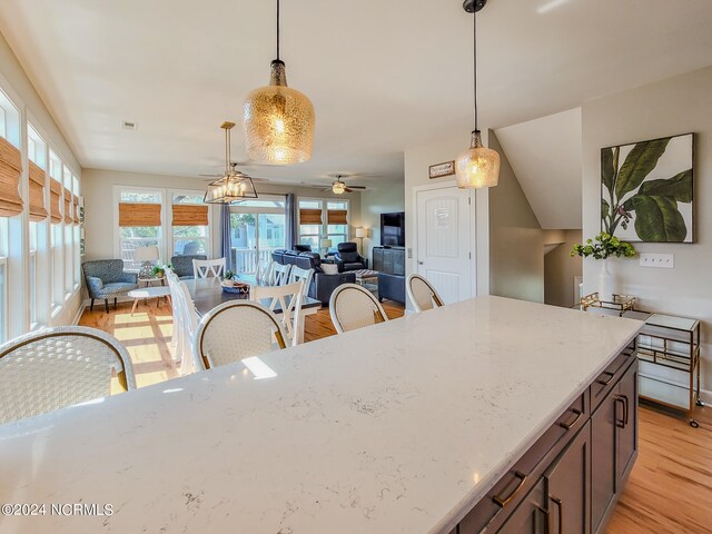 kitchen featuring pendant lighting, light hardwood / wood-style floors, and ceiling fan