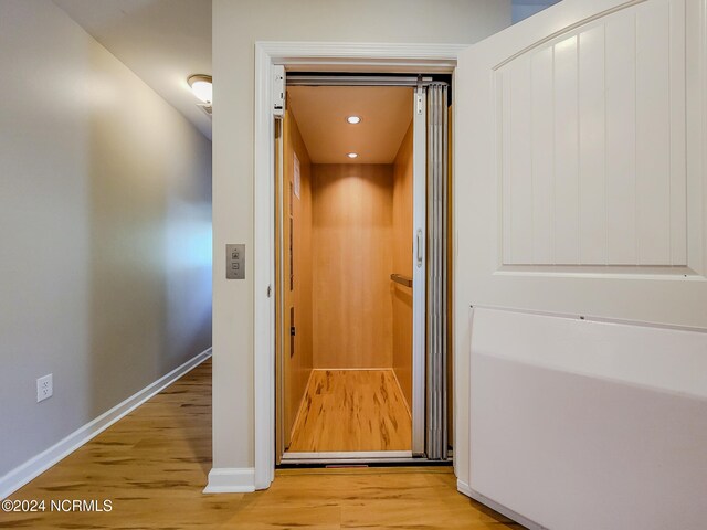 details featuring elevator and hardwood / wood-style floors