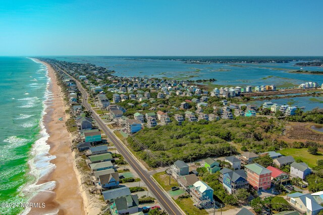 drone / aerial view featuring a water view and a view of the beach