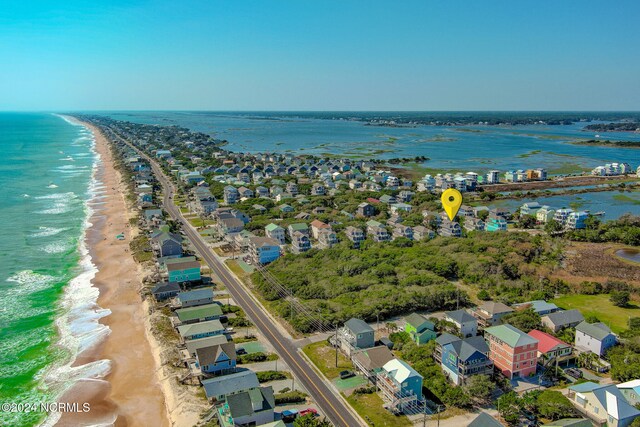 birds eye view of property featuring a water view and a beach view