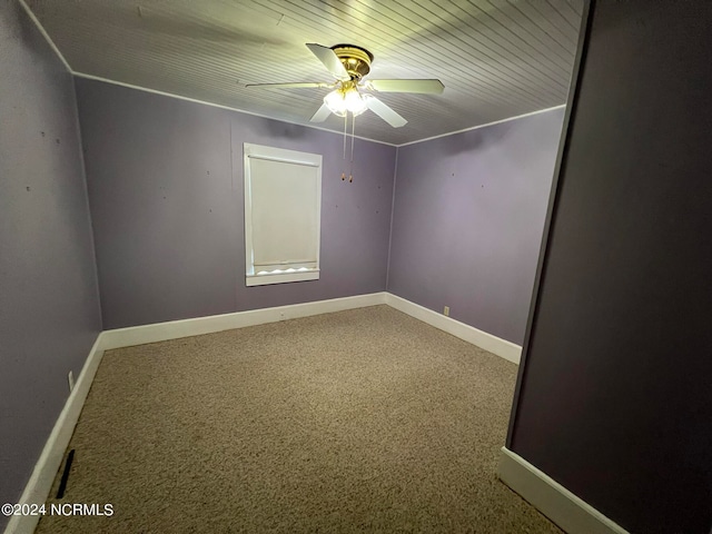 spare room featuring carpet, wood ceiling, and ceiling fan