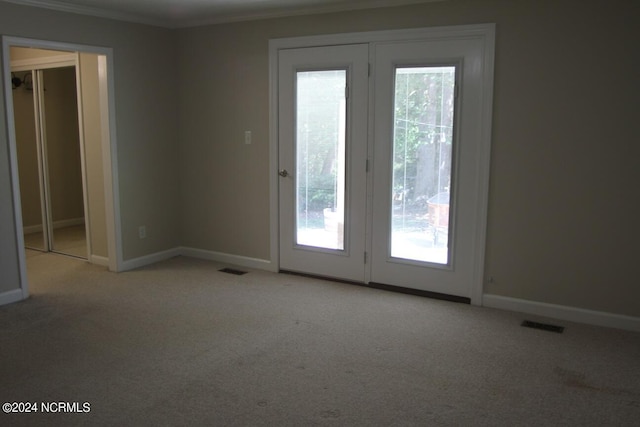 unfurnished room with light carpet, crown molding, and plenty of natural light