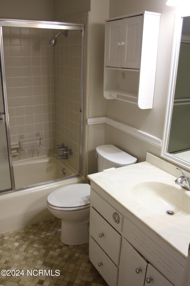 full bathroom featuring toilet, combined bath / shower with glass door, and vanity