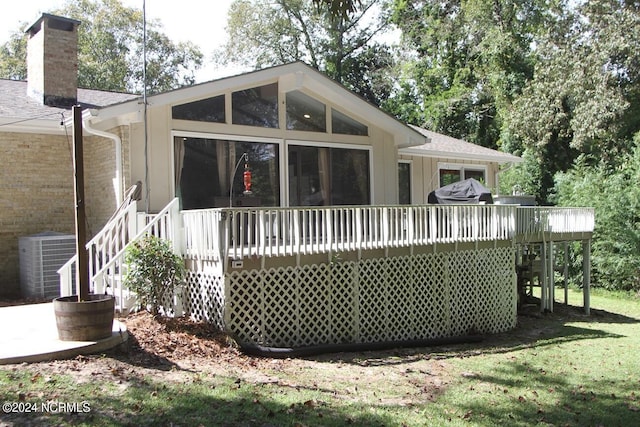 back of house with a wooden deck, a sunroom, a yard, and central AC