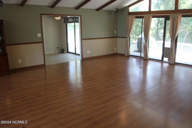 unfurnished room featuring a wealth of natural light, dark hardwood / wood-style floors, and lofted ceiling with beams