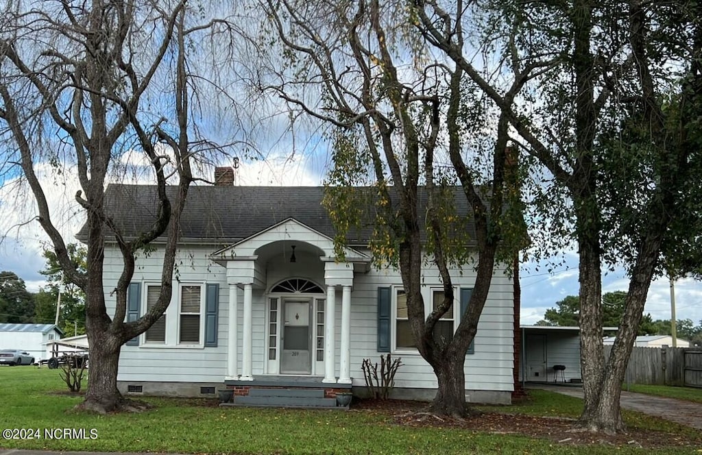 view of front facade with a front yard and a carport