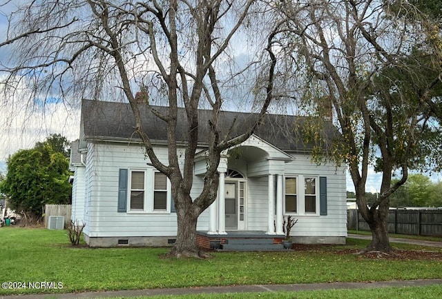 view of front of house with cooling unit and a front lawn