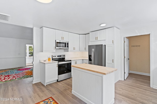 160 NE 5th St, Oak Island, NC 28465 - kitchen featuring appliances with stainless steel finishes, wood counters, light wood-type flooring, and white cabinetry