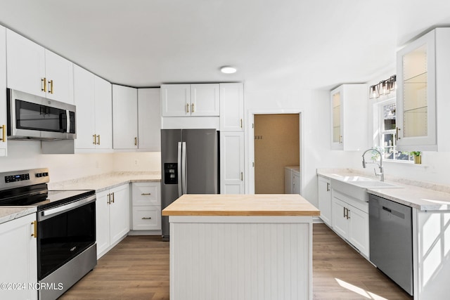 kitchen with stainless steel appliances, a kitchen island, and white cabinetry