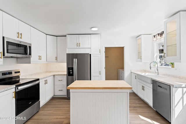 160 NE 5th St, Oak Island, NC 28465 - kitchen with appliances with stainless steel finishes, washer and dryer, a sink, a kitchen island, and wood finished floors