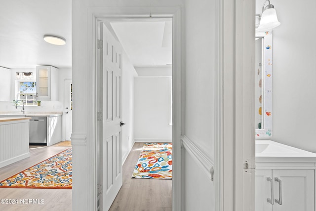 corridor featuring light hardwood / wood-style floors and sink