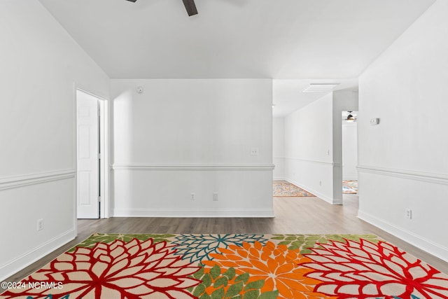 spare room with wood-type flooring, vaulted ceiling, and ceiling fan