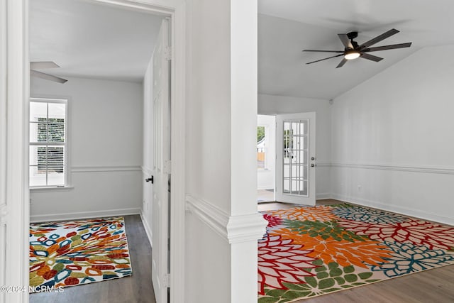 entryway with a wealth of natural light, ceiling fan, dark wood-type flooring, and vaulted ceiling