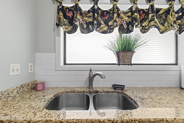 kitchen with light stone countertops and sink