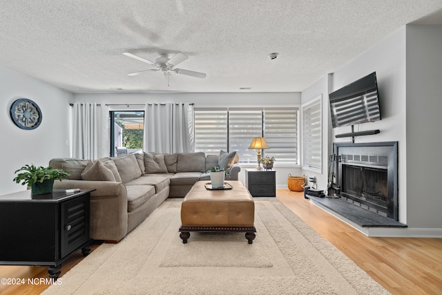 living room featuring ceiling fan, a textured ceiling, and hardwood / wood-style floors