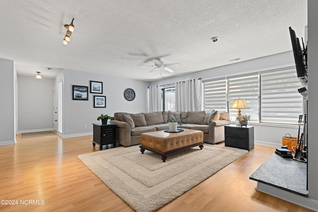 living room featuring ceiling fan, a textured ceiling, and hardwood / wood-style floors