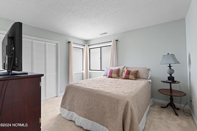 carpeted bedroom featuring a textured ceiling and a closet