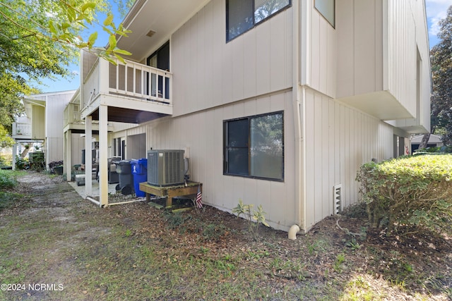 view of side of property featuring cooling unit and a balcony