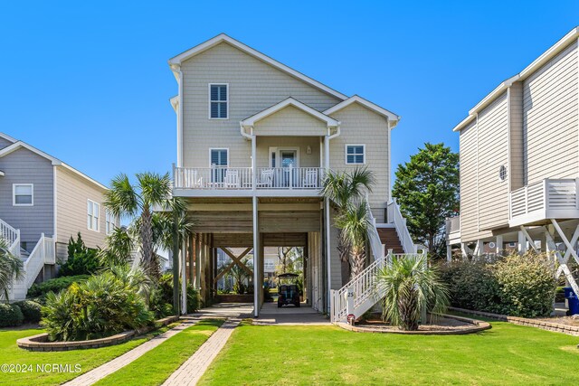 back of property featuring a carport, a lawn, and stairs