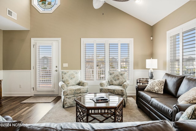 living room with visible vents, high vaulted ceiling, wood finished floors, and wainscoting