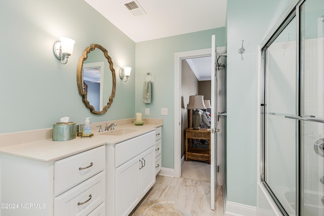 bathroom with vanity, combined bath / shower with glass door, and crown molding