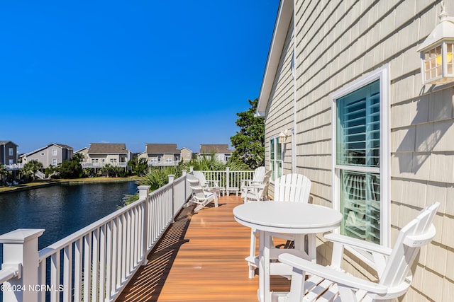 wooden deck with a residential view and a water view