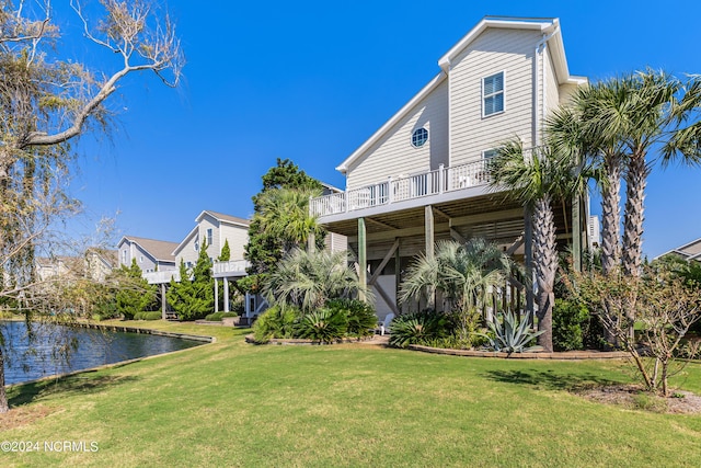 back of property with a yard and a water view