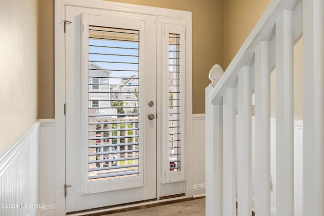 foyer entrance featuring a wainscoted wall and a decorative wall