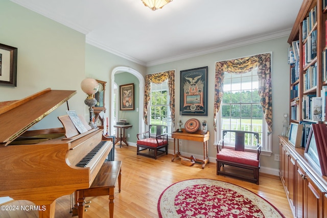 living area with light hardwood / wood-style flooring and ornamental molding