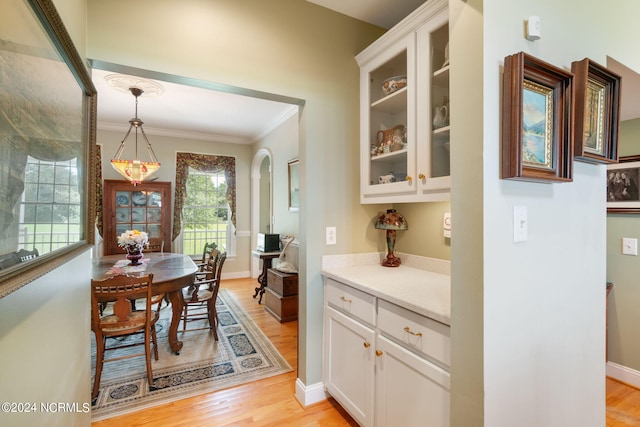 dining room featuring crown molding and light hardwood / wood-style flooring