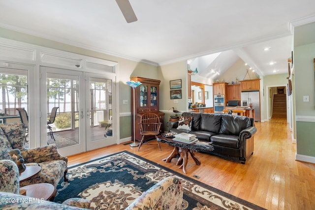 living room with ceiling fan, french doors, light hardwood / wood-style flooring, crown molding, and lofted ceiling