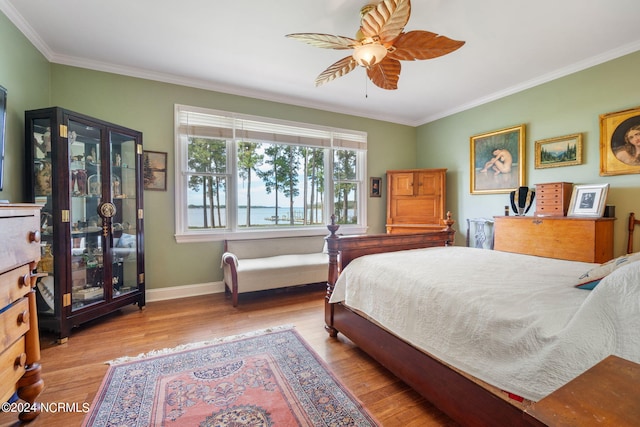 bedroom with ceiling fan, crown molding, and light hardwood / wood-style floors