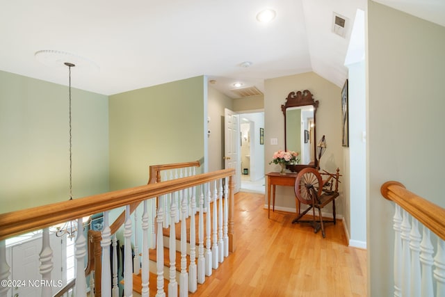 hallway featuring light hardwood / wood-style floors and lofted ceiling