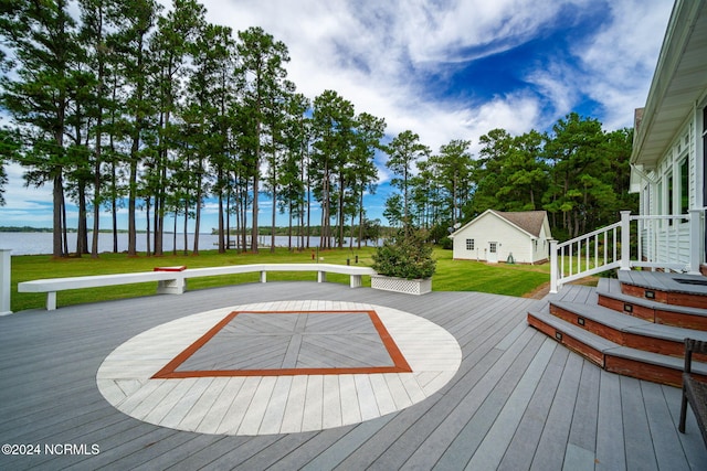 wooden terrace with a water view and a lawn