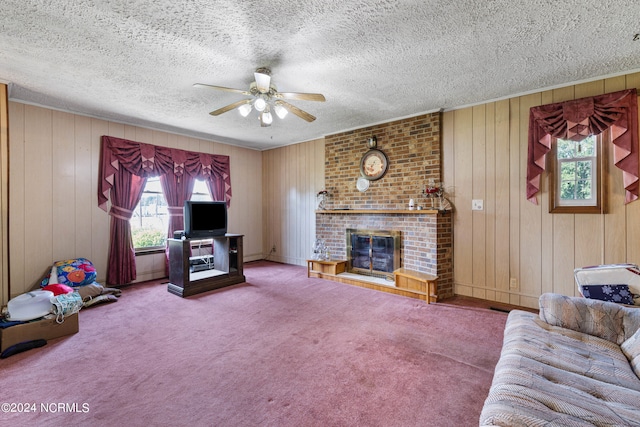 unfurnished living room featuring a brick fireplace, carpet flooring, a textured ceiling, and ceiling fan