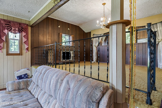 carpeted living room featuring vaulted ceiling, a chandelier, a textured ceiling, and wooden walls