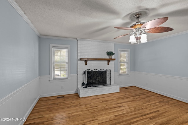 unfurnished living room featuring a textured ceiling, a brick fireplace, and light hardwood / wood-style flooring