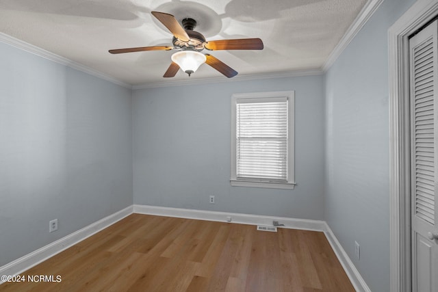 empty room featuring ornamental molding, light hardwood / wood-style flooring, a textured ceiling, and ceiling fan