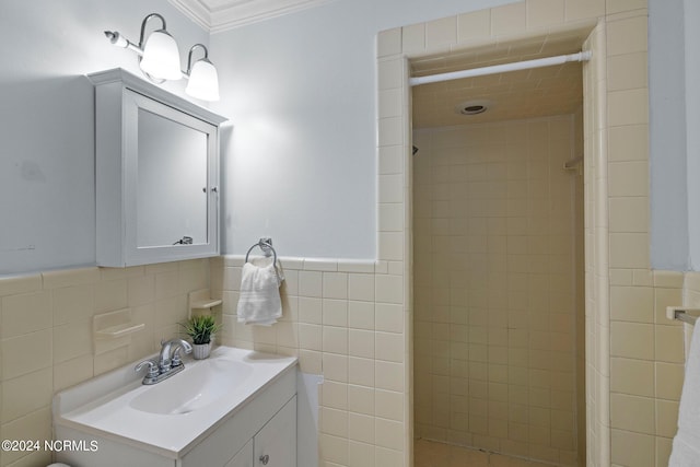 bathroom with crown molding, tiled shower, vanity, and tile walls