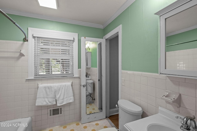 full bathroom with plus walk in shower, sink, tile walls, ornamental molding, and toilet