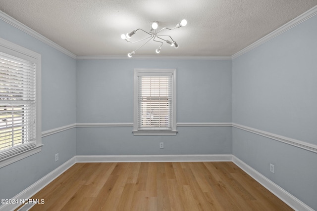 unfurnished room with crown molding, an inviting chandelier, light hardwood / wood-style floors, and a textured ceiling