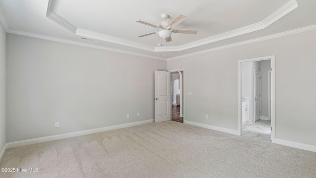 unfurnished bedroom with carpet flooring, crown molding, visible vents, baseboards, and a raised ceiling
