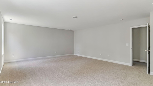 carpeted empty room featuring visible vents and baseboards