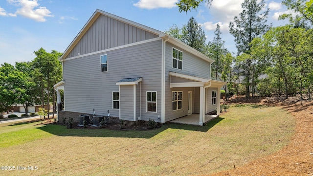 view of home's exterior with board and batten siding, a patio, central AC unit, and a lawn