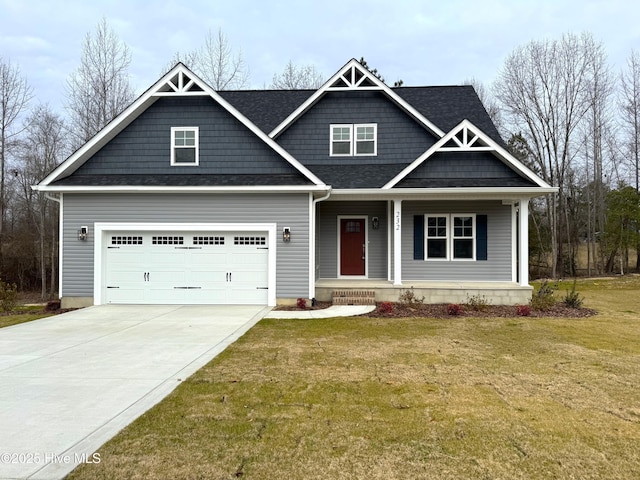 craftsman house featuring covered porch, a front yard, and a garage