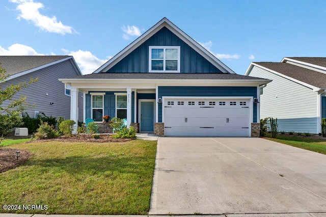 view of front of home with a front yard, a porch, and a garage