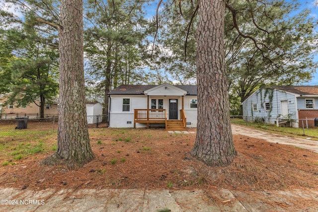 bungalow-style house featuring a wooden deck, crawl space, fence, and a shingled roof