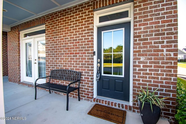 doorway to property featuring french doors and brick siding