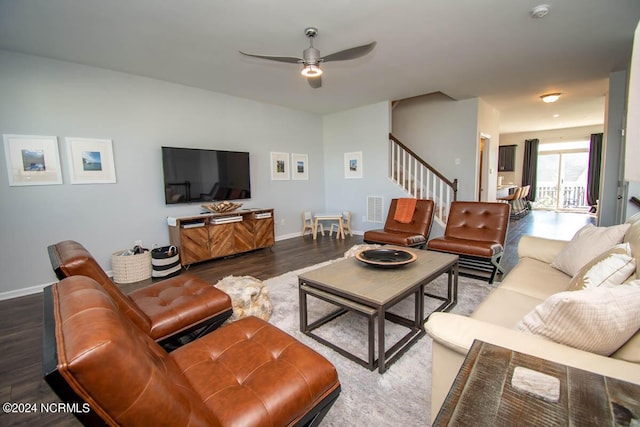 living area featuring a ceiling fan, visible vents, baseboards, dark wood-style floors, and stairs