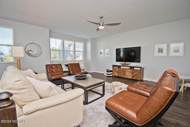 living area featuring baseboards, ceiling fan, and dark wood-style flooring